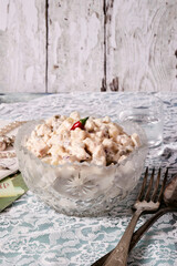 Salad in a crystal vase on a table with guipure. Retro. Beads, cupronickel, old letters