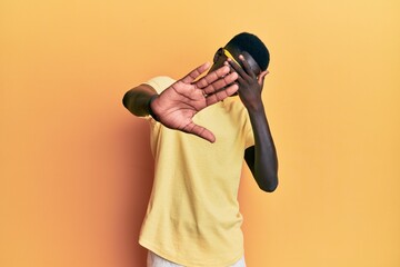 Young african american man wearing casual clothes and glasses covering eyes with hands and doing stop gesture with sad and fear expression. embarrassed and negative concept.