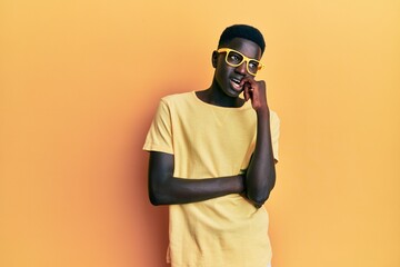 Young african american man wearing casual clothes and glasses looking stressed and nervous with...