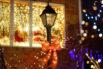 Close-up photo of street lamp with yellow garland on background. Street decorated for Christmas and New Year Holidays