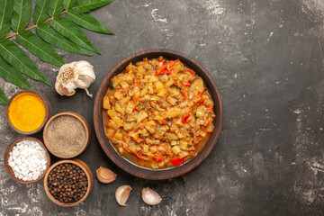 top view roasted eggplant salad in bowl garlic different spices in small bowls on dark background copy space