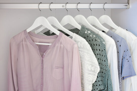Colorful collection of modern women's clothes hanging on a rack in the wardrobe