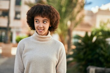 Young hispanic girl smiling happy standing at the city.