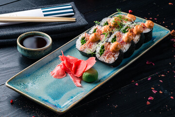 delicious sushi served in Japanese restaurant, sushi with chopsticks on wooden background