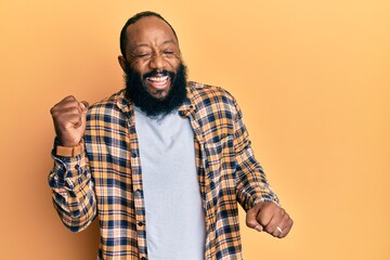 Young african american man wearing casual clothes celebrating surprised and amazed for success with arms raised and eyes closed