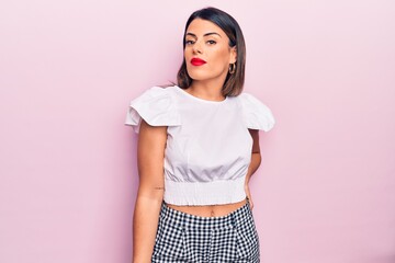 Young beautiful brunette woman wearing casual clothes standing over isolated pink background