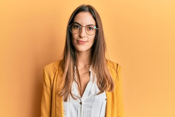 Young beautiful woman wearing business style and glasses relaxed with serious expression on face....
