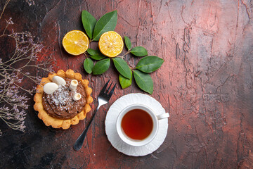 top view cup of tea with delicious little cake on dark background dessert biscuit cookie
