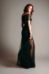 Black transparent long evening dress. Beautiful slim bending model, modern feminine look for a...