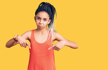 Cute african american girl wearing casual clothes pointing down looking sad and upset, indicating direction with fingers, unhappy and depressed.