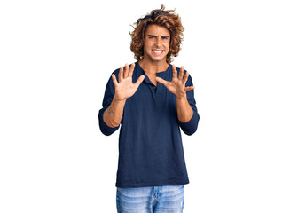 Young hispanic man wearing casual clothes disgusted expression, displeased and fearful doing disgust face because aversion reaction. with hands raised