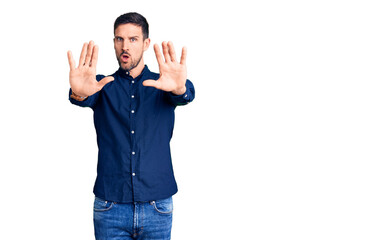 Young handsome man wearing casual shirt doing stop gesture with hands palms, angry and frustration expression