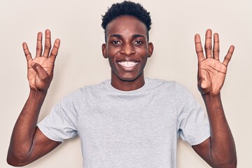 Naklejka premium Young african american man wearing casual clothes showing and pointing up with fingers number nine while smiling confident and happy.