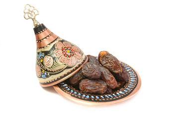 Naklejka premium Natural dried dates (fruits of date palm Phoenix dactylifera) in traditional hand made cooper bowl. isolated on white background