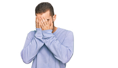 Young caucasian man wearing casual clothes with sad expression covering face with hands while crying. depression concept.