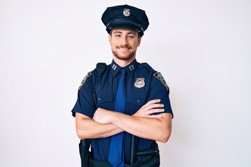 Young caucasian man wearing police uniform happy face smiling with crossed arms looking at the...
