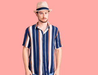 Young handsome caucasian man wearing summer hat skeptic and nervous, frowning upset because of problem. negative person.