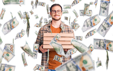 Young handsome caucasian man holding delivery pizza box looking positive and happy standing and smiling with a confident smile showing teeth