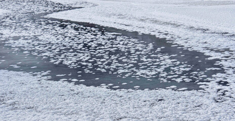 Snow crystals on the ice of a frozen river