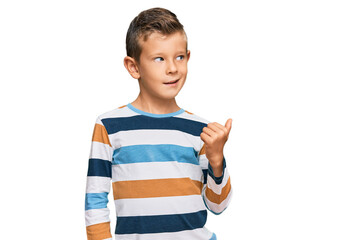 Adorable caucasian kid wearing casual clothes smiling with happy face looking and pointing to the side with thumb up.