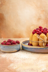 Vertical view of freshly baked soft cake with fruits on mixed color background