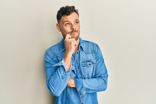 Young hispanic man wearing casual clothes thinking concentrated about doubt with finger on chin and looking up wondering