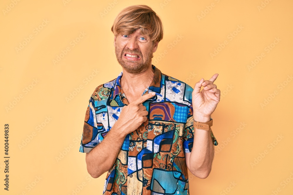 Poster Young blond man wearing summer shirt pointing aside worried and nervous with both hands, concerned and surprised expression