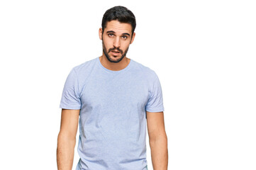 Obraz premium Young hispanic man wearing casual clothes in shock face, looking skeptical and sarcastic, surprised with open mouth