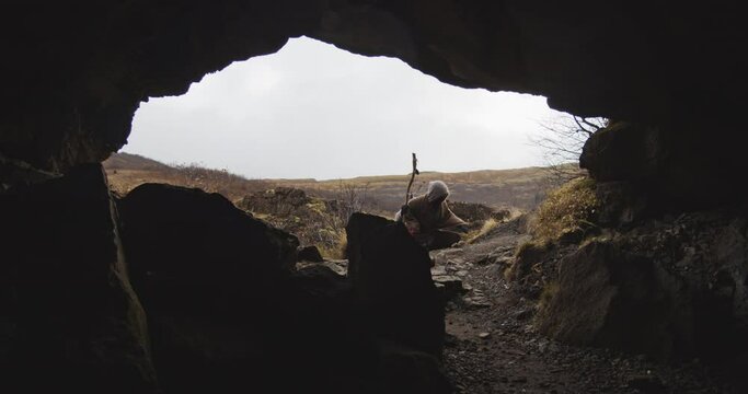 Hooded Figure Entering Cave