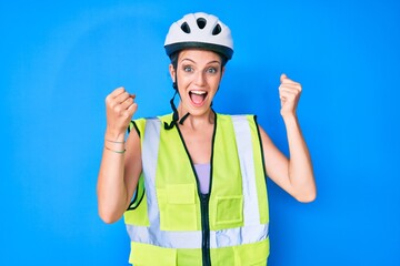Young caucasian girl wearing bike helmet and reflective vest screaming proud, celebrating victory...
