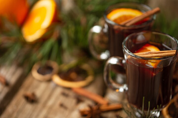 Macro shot view of glasses of mulled wine on spruce cone and branch background. fragrant spices. Festive mood. Hot alcoholic drinks.