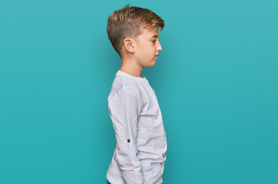 Little caucasian boy kid wearing casual clothes looking to side, relax profile pose with natural face with confident smile.