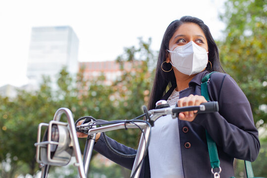 Business Woman With Mask, She Is Standing And Has A Bicycle. Carry A Green Bag