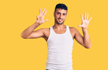 Young hispanic man wearing casual clothes showing and pointing up with fingers number nine while...