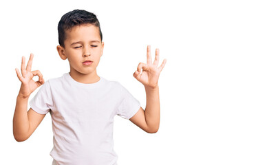 Little cute boy kid wearing casual white tshirt relax and smiling with eyes closed doing meditation gesture with fingers. yoga concept.