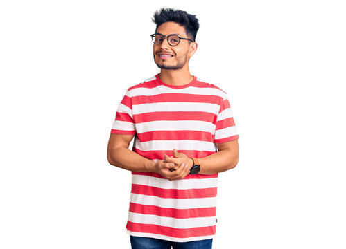 Handsome latin american young man wearing casual clothes and glasses with hands together and crossed fingers smiling relaxed and cheerful. success and optimistic