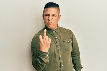 Young latin man wearing casual clothes showing middle finger, impolite and rude fuck off expression