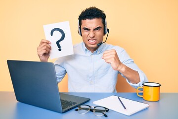 Young handsome hispanic man holding question mark as customer support annoyed and frustrated shouting with anger, yelling crazy with anger and hand raised