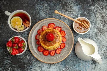 top view yummy pancakes with fruits and cup of tea on light background sweet cake fruit