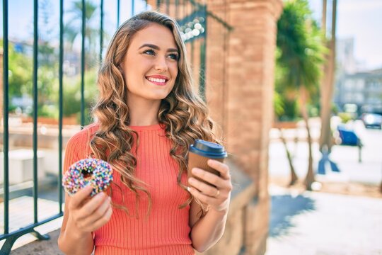 Young blonde girl smiling happy having breakfast at the city.