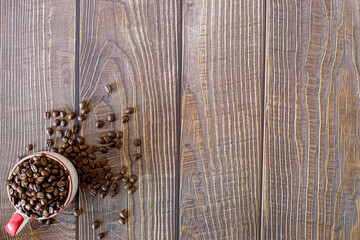 Coffee beans roasted in a cup with a wooden background can be used as a background.