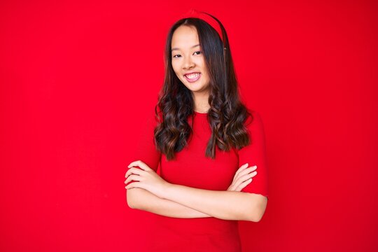 Young beautiful chinese girl wearing casual clothes happy face smiling with crossed arms looking at the camera. positive person.