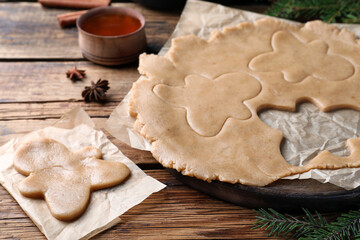 Making homemade Christmas cookies. Dough for gingerbread man on wooden table, closeup