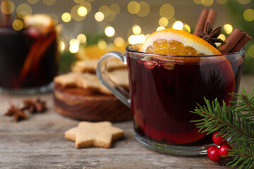 Aromatic mulled wine on wooden table, closeup. Space for text