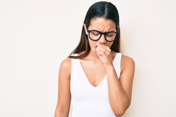 Young beautiful latin girl wearing casual clothes and glasses feeling unwell and coughing as symptom for cold or bronchitis. health care concept.