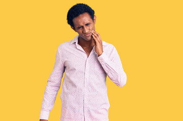 African handsome man wearing casual pink shirt touching mouth with hand with painful expression because of toothache or dental illness on teeth. dentist