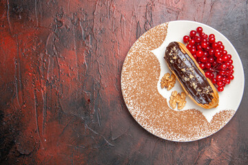 top view delicious choco eclairs with red berries on dark background pie dessert cakes sweet