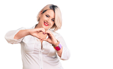 Young blonde plus size woman wearing casual shirt smiling in love doing heart symbol shape with hands. romantic concept.