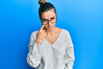 Young hispanic woman wearing casual clothes pointing to the eye watching you gesture, suspicious expression