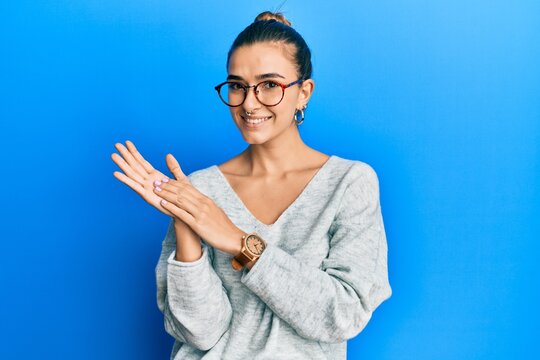 Young hispanic woman wearing casual clothes clapping and applauding happy and joyful, smiling proud hands together